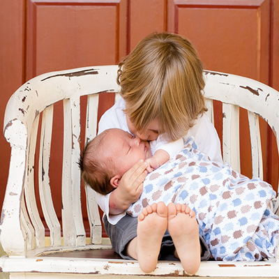 Un bébé dans les bras d'un enfant